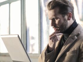 Man holding his chin facing a laptop